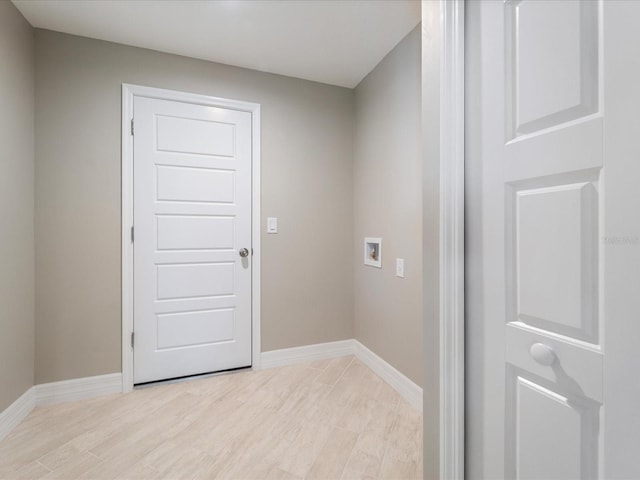 clothes washing area with hookup for a washing machine and light hardwood / wood-style floors