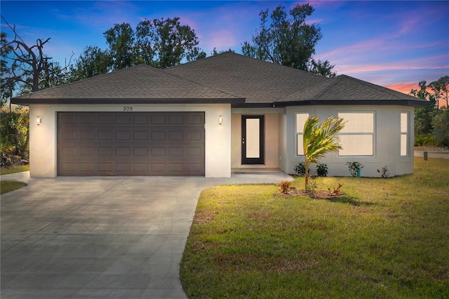 view of front of home with a garage and a yard