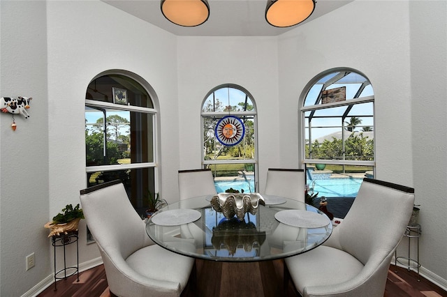 dining space with dark wood-type flooring and a healthy amount of sunlight