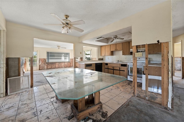 kitchen with stove, backsplash, a wealth of natural light, and kitchen peninsula