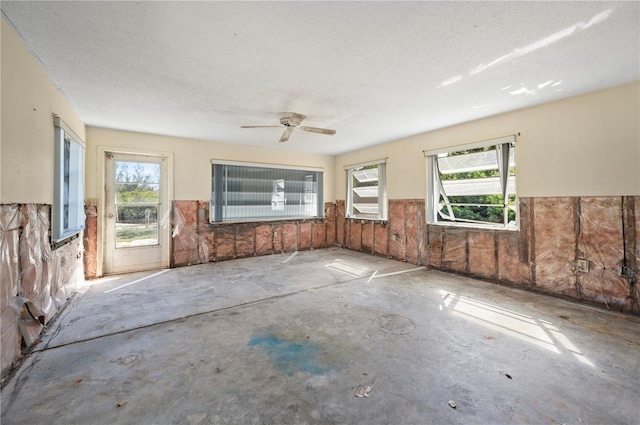 interior space with plenty of natural light, concrete floors, and a textured ceiling