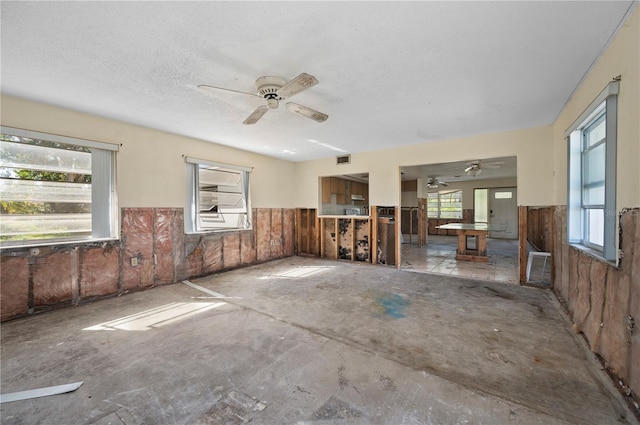 interior space with ceiling fan and a textured ceiling