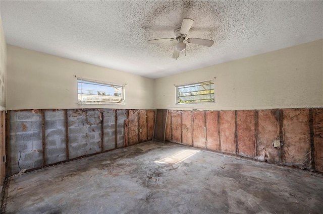 unfurnished room featuring ceiling fan and a textured ceiling