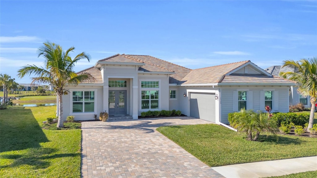 view of front of house featuring a garage, a front lawn, and french doors