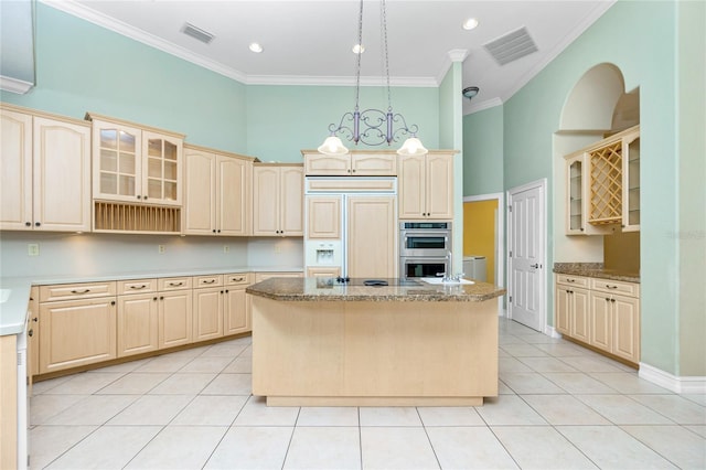 kitchen featuring visible vents, a center island, a high ceiling, and paneled refrigerator