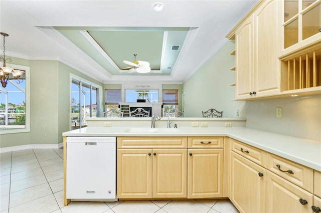 kitchen featuring light brown cabinets, a peninsula, a tray ceiling, and white dishwasher