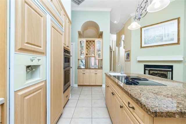 kitchen with light brown cabinetry, light tile patterned flooring, crown molding, black electric cooktop, and light stone countertops