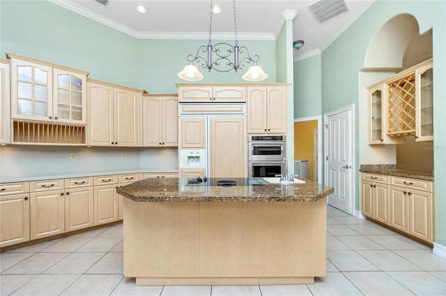 kitchen featuring paneled fridge, a high ceiling, ornamental molding, and a center island