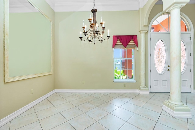 tiled entryway featuring baseboards, a chandelier, crown molding, and ornate columns