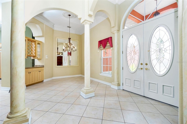 entryway featuring baseboards, ornamental molding, french doors, light tile patterned flooring, and ornate columns