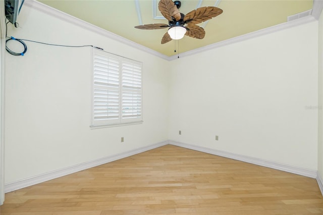 spare room featuring crown molding, baseboards, visible vents, and light wood-type flooring