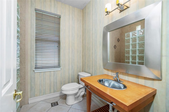 bathroom with toilet, wallpapered walls, tile patterned flooring, baseboards, and vanity