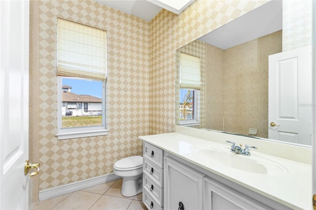 bathroom featuring tile patterned floors, toilet, wallpapered walls, and a healthy amount of sunlight