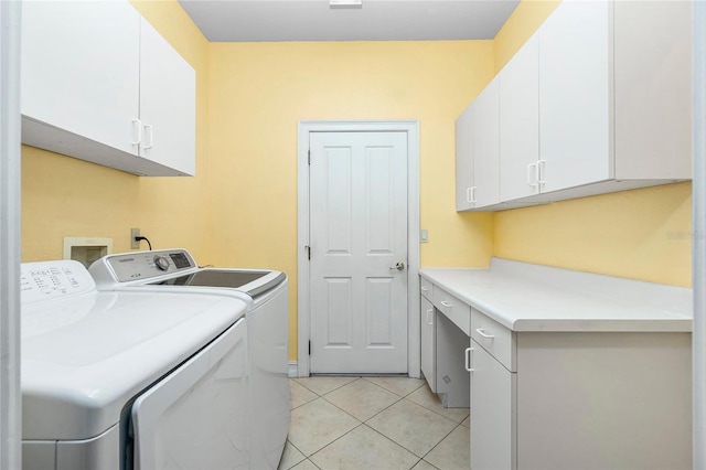 laundry area featuring light tile patterned floors, cabinet space, and washing machine and dryer