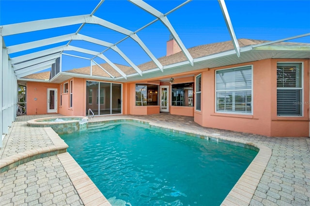 view of pool featuring a patio, a ceiling fan, a pool with connected hot tub, and a lanai