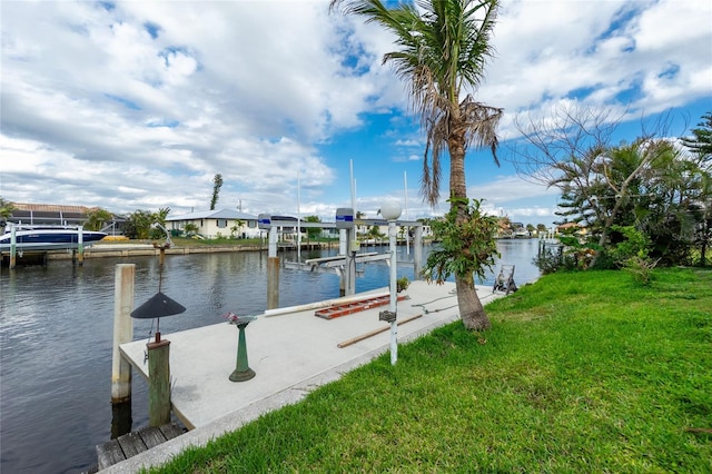 view of dock featuring a yard, a water view, and boat lift