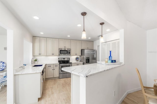 kitchen with pendant lighting, appliances with stainless steel finishes, kitchen peninsula, and light stone countertops