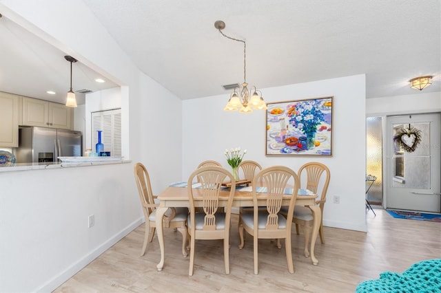 dining room featuring light hardwood / wood-style floors and a chandelier