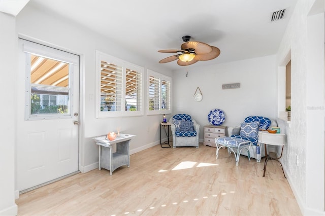 sitting room with ceiling fan and light wood-type flooring