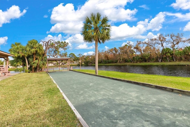 surrounding community with a water view and a yard