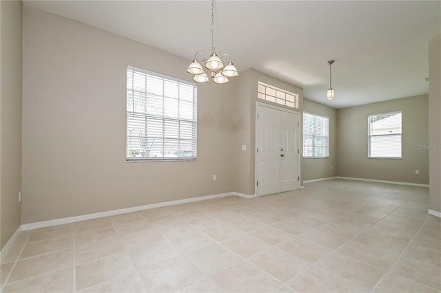 tiled entrance foyer with a wealth of natural light and a notable chandelier