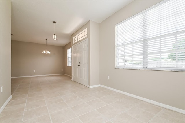 foyer with a notable chandelier and light tile patterned floors