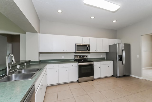 kitchen with white cabinetry, stainless steel appliances, sink, and light tile patterned floors