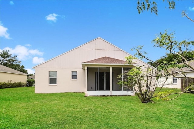 rear view of property featuring a sunroom and a lawn