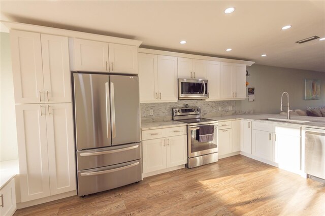 kitchen featuring white cabinetry, stainless steel appliances, light hardwood / wood-style floors, and sink