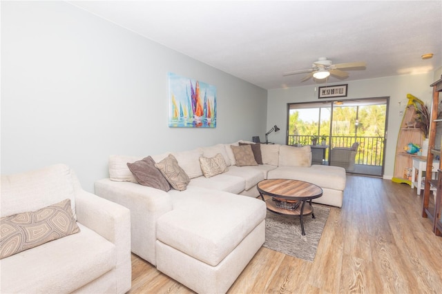 living room featuring light hardwood / wood-style flooring and ceiling fan