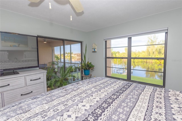 unfurnished bedroom featuring ceiling fan and a water view