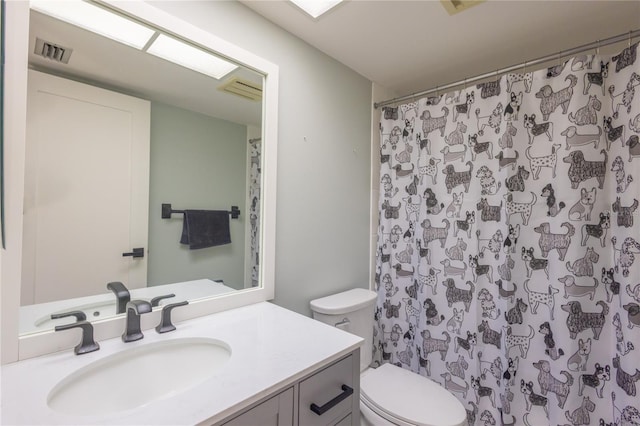 bathroom with vanity, walk in shower, and toilet