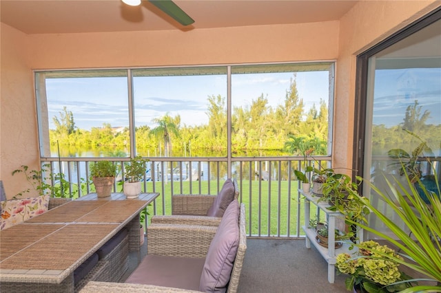 sunroom / solarium with a water view and ceiling fan