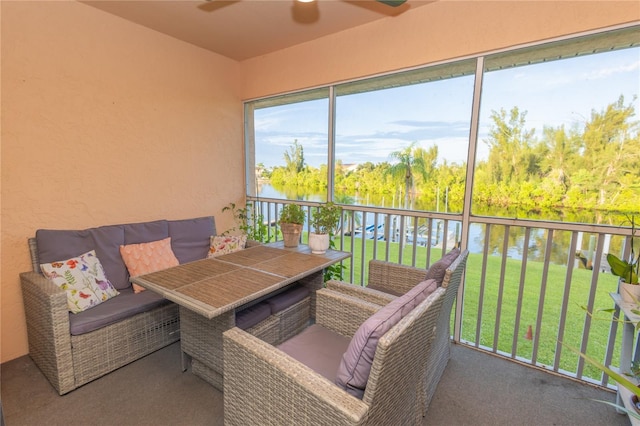 sunroom with a water view and ceiling fan