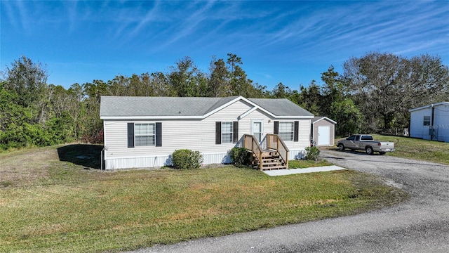 manufactured / mobile home featuring a garage and a front yard