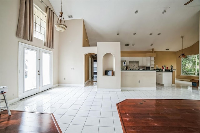 unfurnished living room featuring light tile patterned flooring and french doors