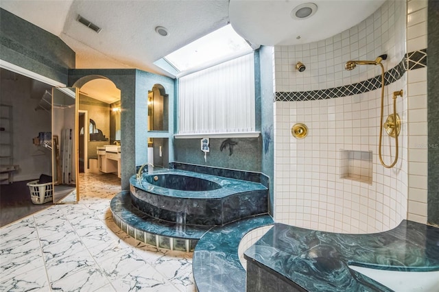 bathroom with vaulted ceiling with skylight, a textured ceiling, and plus walk in shower