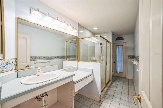 bathroom featuring a shower with door, vanity, and tile patterned flooring