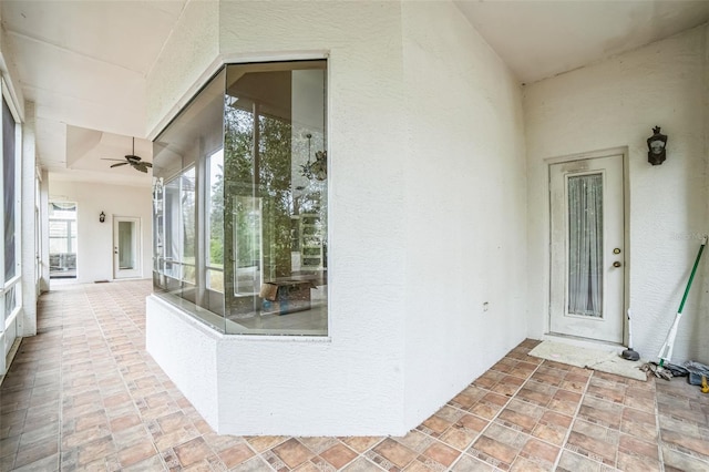 entrance to property featuring ceiling fan and a patio