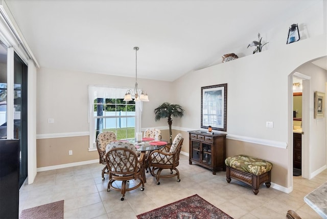 tiled dining room with an inviting chandelier and vaulted ceiling