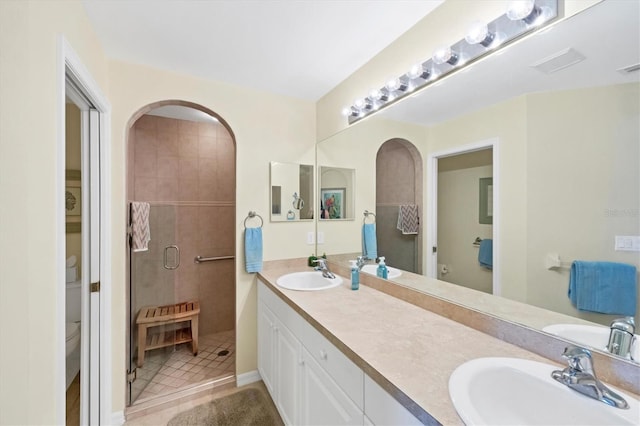 bathroom featuring tile patterned flooring, vanity, an enclosed shower, and toilet