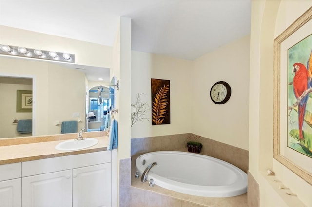 bathroom featuring vanity and a relaxing tiled tub