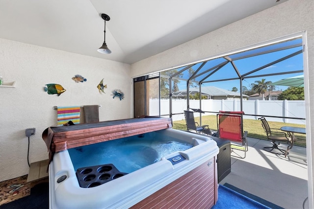 view of patio / terrace featuring a hot tub and glass enclosure