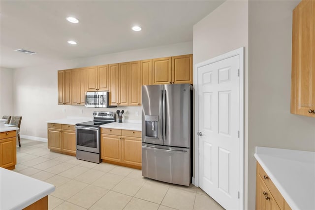 kitchen featuring light brown cabinetry, light tile patterned floors, and appliances with stainless steel finishes