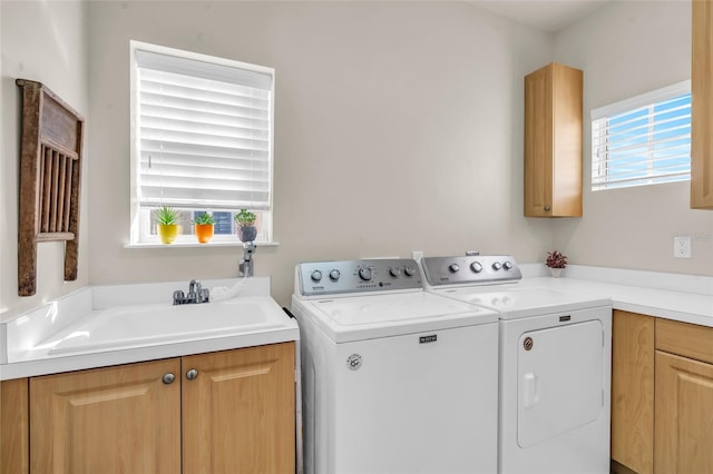 laundry room featuring cabinets, a healthy amount of sunlight, separate washer and dryer, and sink