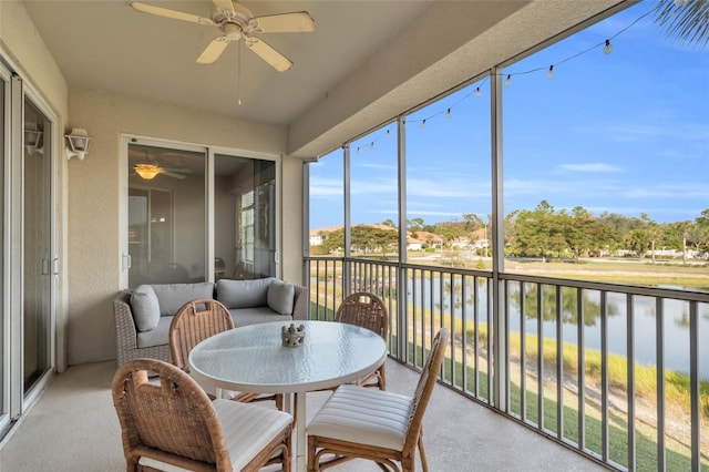 sunroom / solarium with a water view and ceiling fan