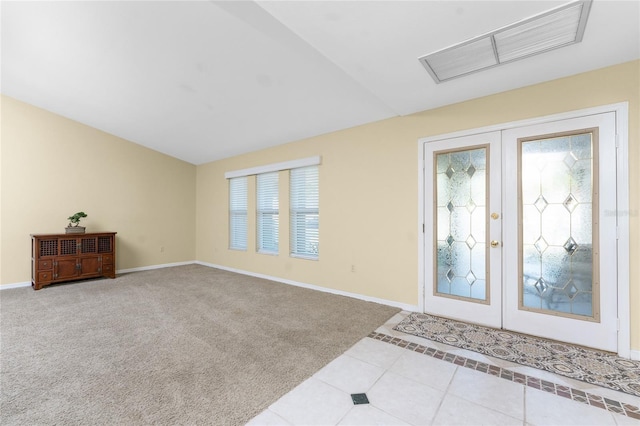 carpeted entrance foyer featuring lofted ceiling and french doors