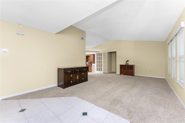 carpeted living room featuring french doors and lofted ceiling