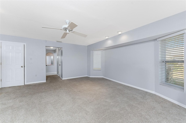 carpeted spare room featuring ceiling fan