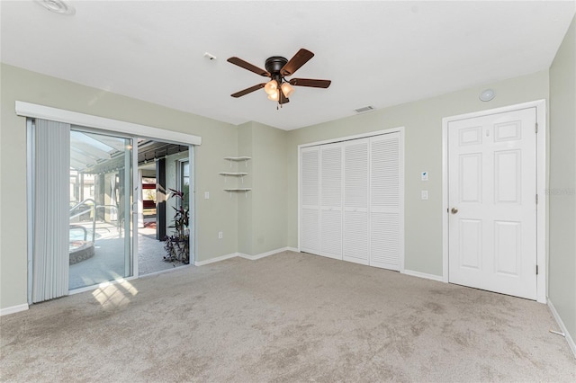 unfurnished bedroom featuring ceiling fan, a closet, light carpet, and access to outside